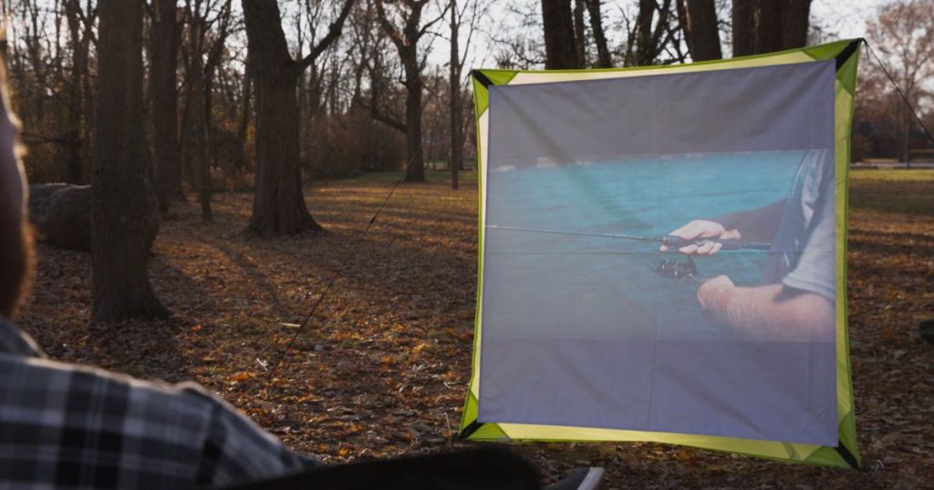 Ozark trail projection screen 59" x 59" assembled with a fishing show being projected on to it
