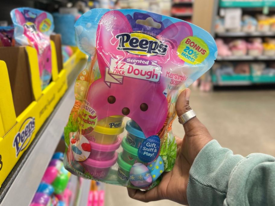 A hand holding Peeps Scented Dough in a store