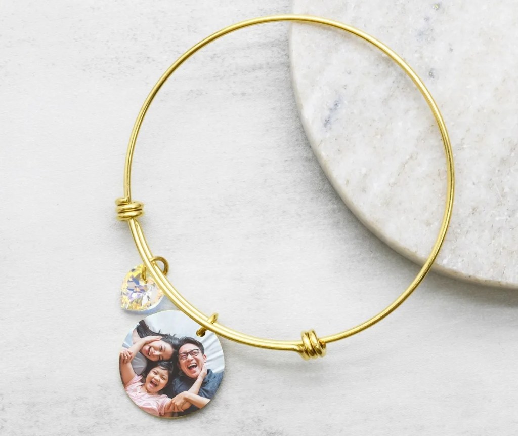 Gold bracelet with a picture of a family as a charm on it