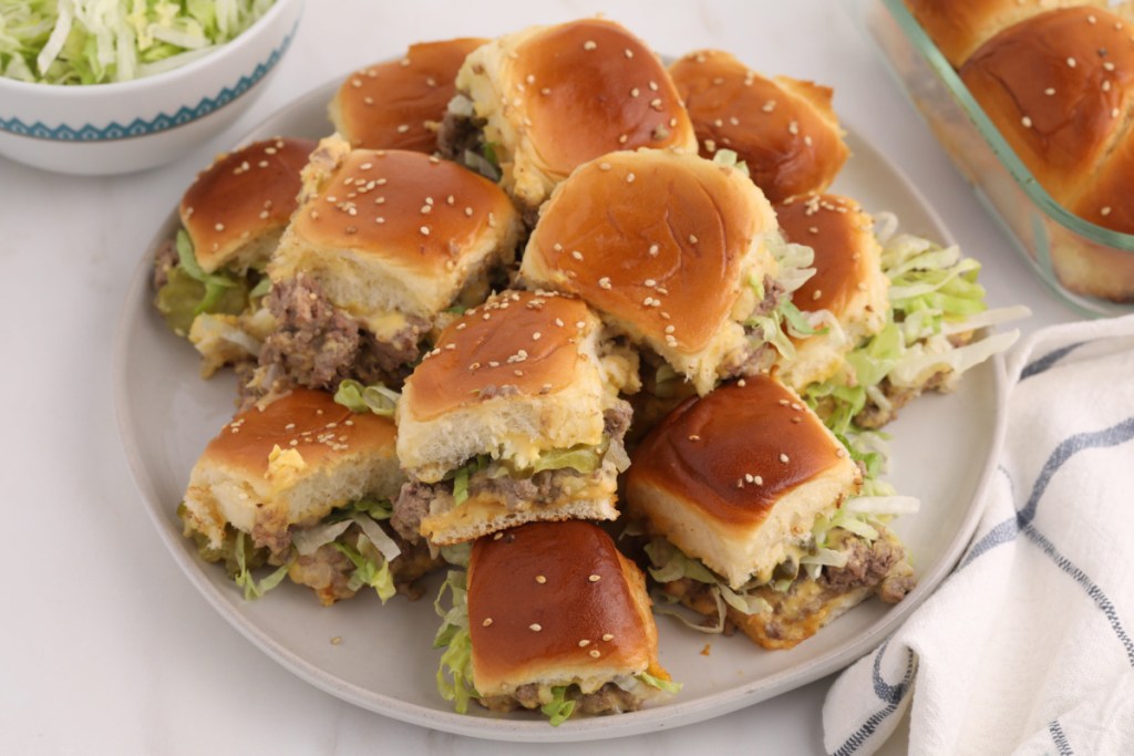 A plate piled high with homemade big mac sliders for a party