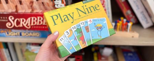 hand taking Play Nine board game from shelf
