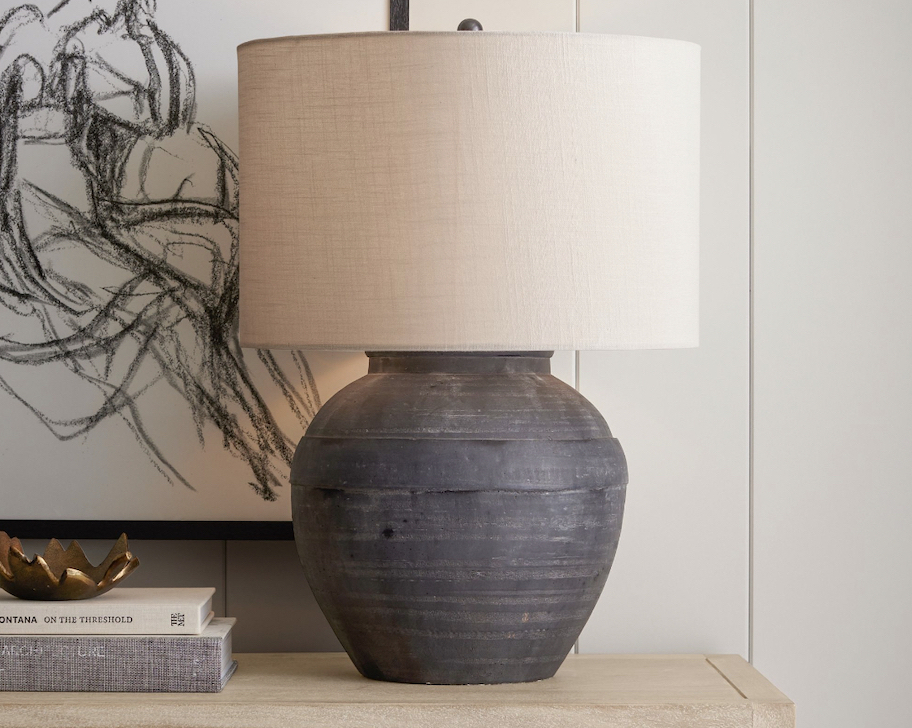 dark gray and beige table lamp on wood table with books