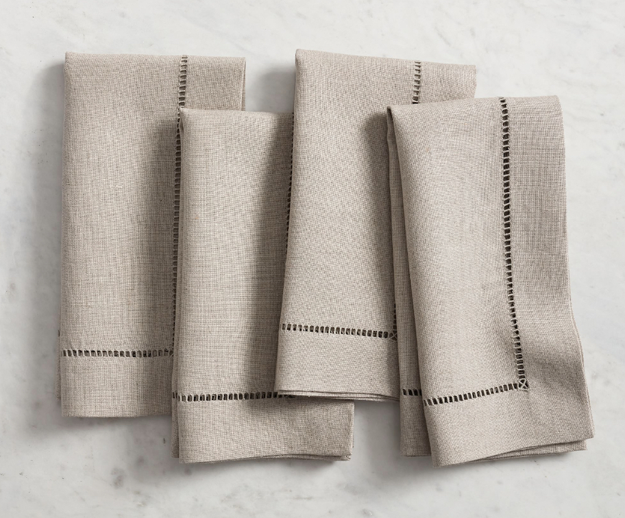 beige hemstitch napkins laying on gray table
