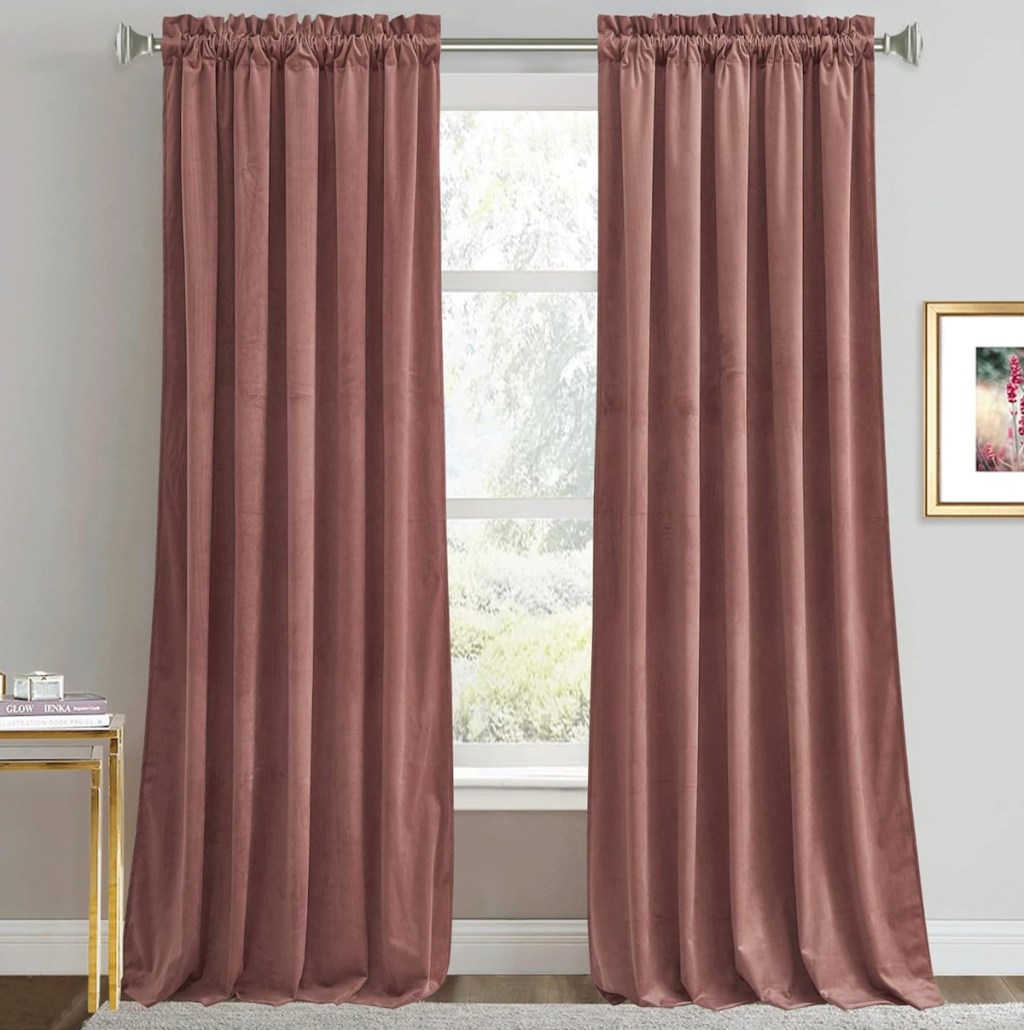 To mauve colored velvet curtains, hanging on curtain rod in front of window