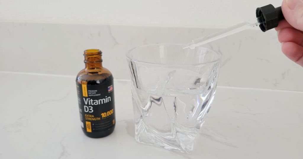Raw Science Vitamin D3 Drop Supplement shown with drops being poured in glass of water