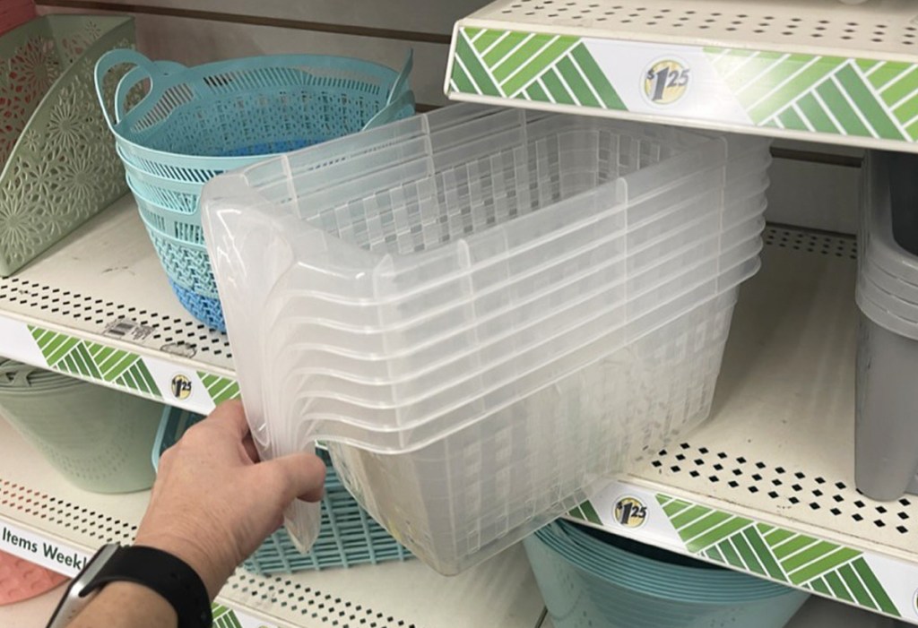 hand grabbing stack of storage baskets from shelf