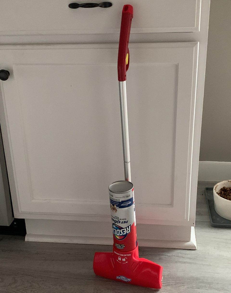 Resolve carpet cleaner brush leaning against a cabinet