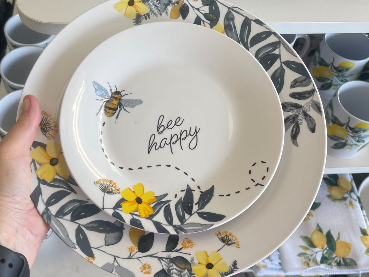 A small plate inside a larger plate with bees and yellow flowers on it. 