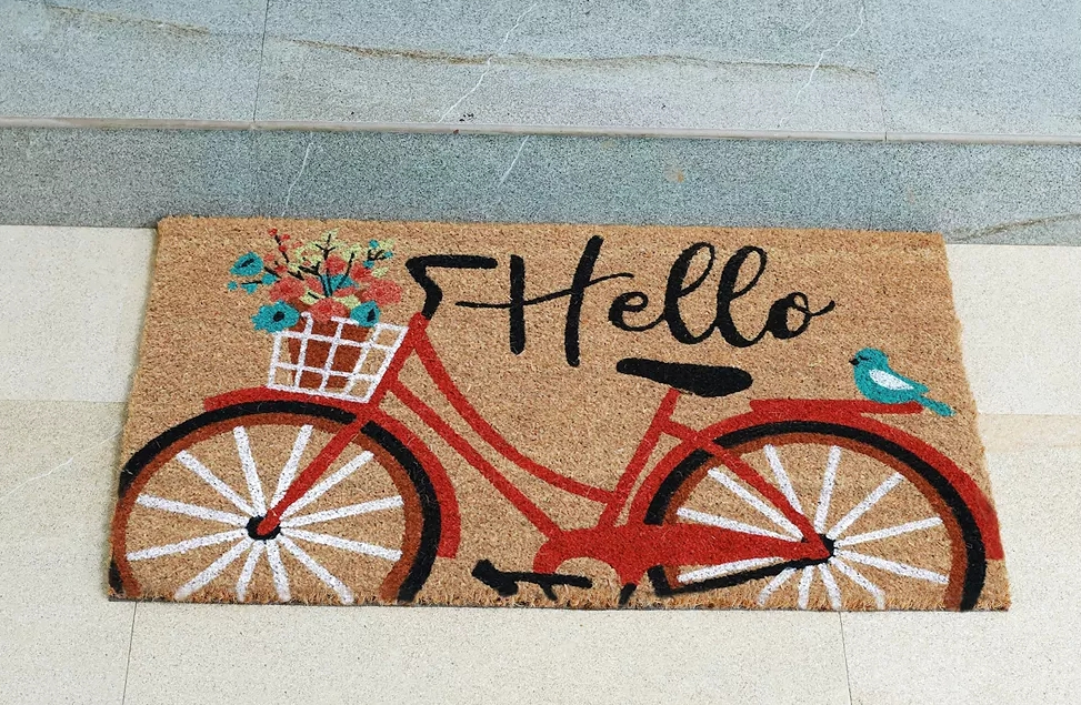 Fußmatte mit einem Fahrrad darauf, auf dem Hallo steht