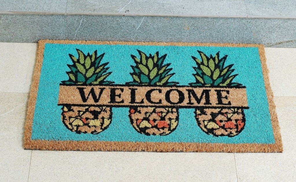 Doormat with a blue background, three pineapples and the word Welcome