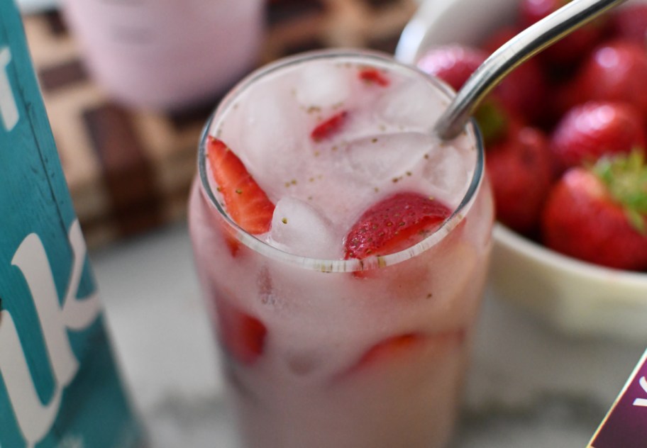 A delicious Starbucks pink drink copycat recipe next to the simple ingredients like strawberries and silk