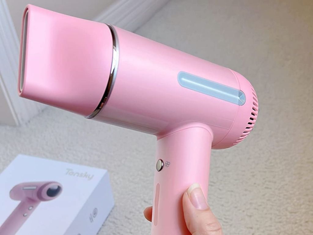 Hand holding a pink hair dryer