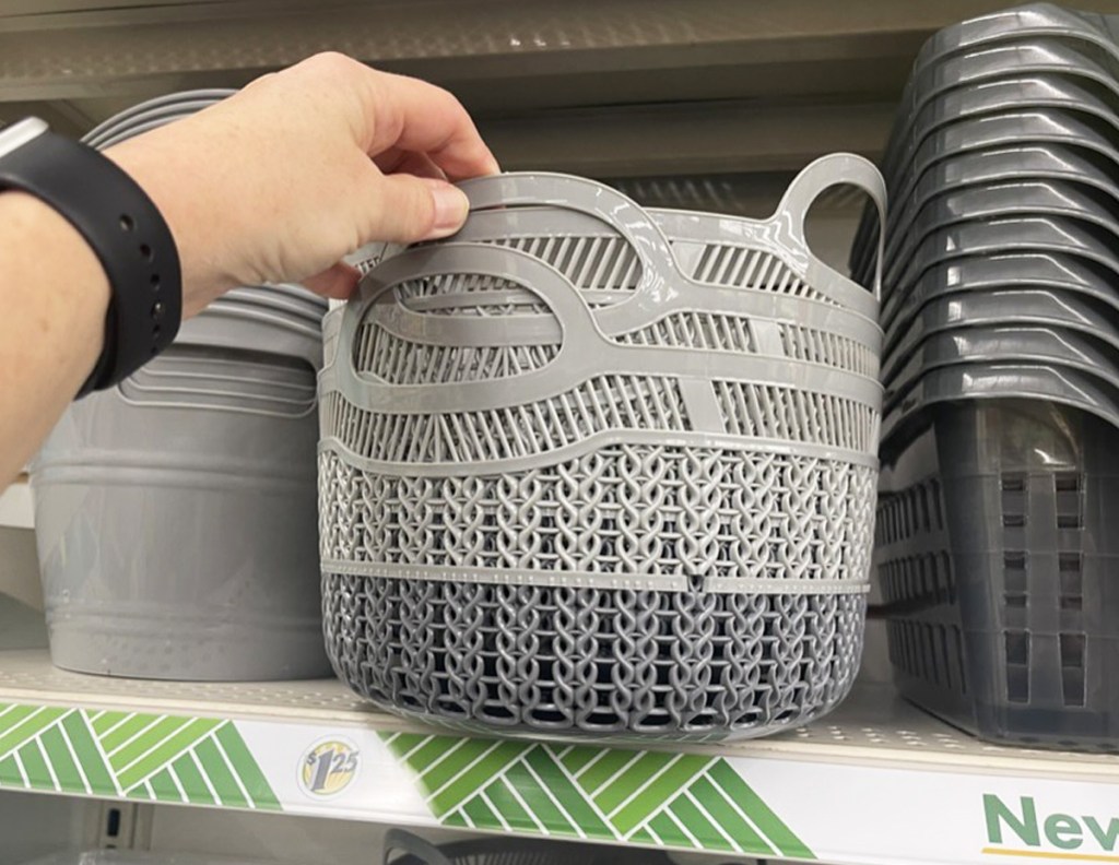 hand touching grey storage basket