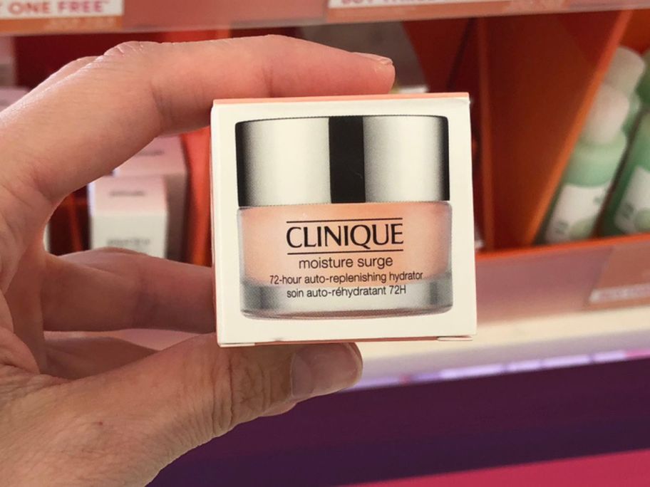 Hand holding a mini clinique Moisture Surge