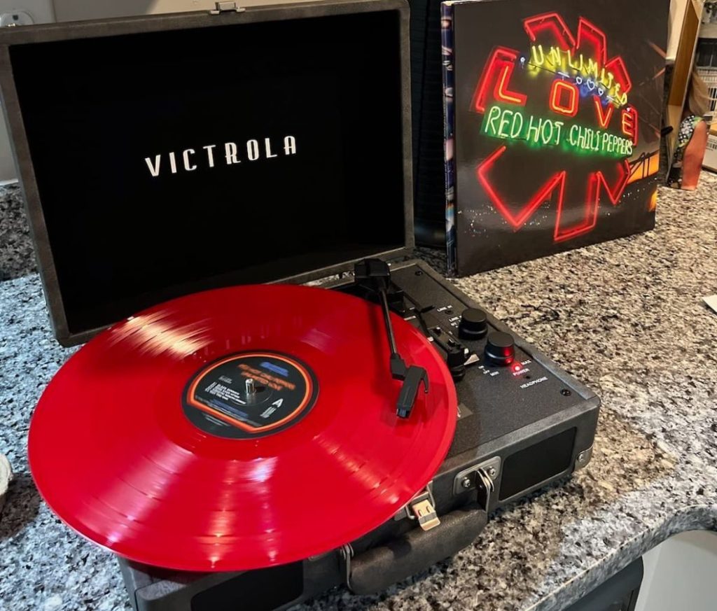 Victrola Record Player with a red record on it and a case for a red hot chili peppers album next to it