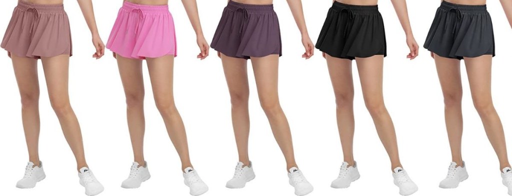 row of five women wearing shorts in pink, maroon, grey, and black