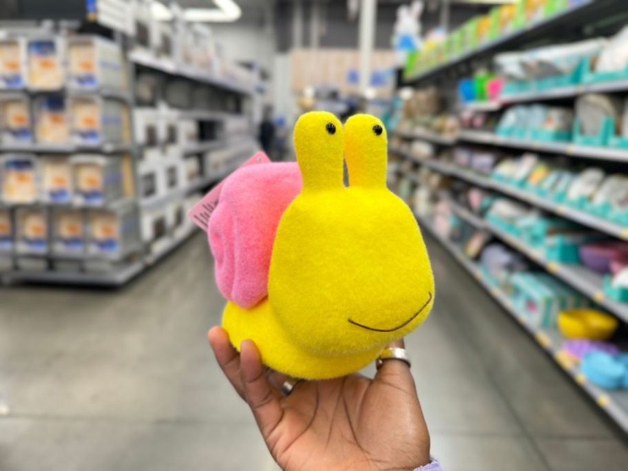 small yellow and pink flocked snail decor in person's hand