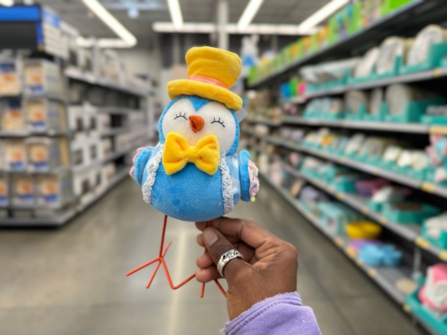 Easter bird in blue with yellow hat and bow tie in person's hand
