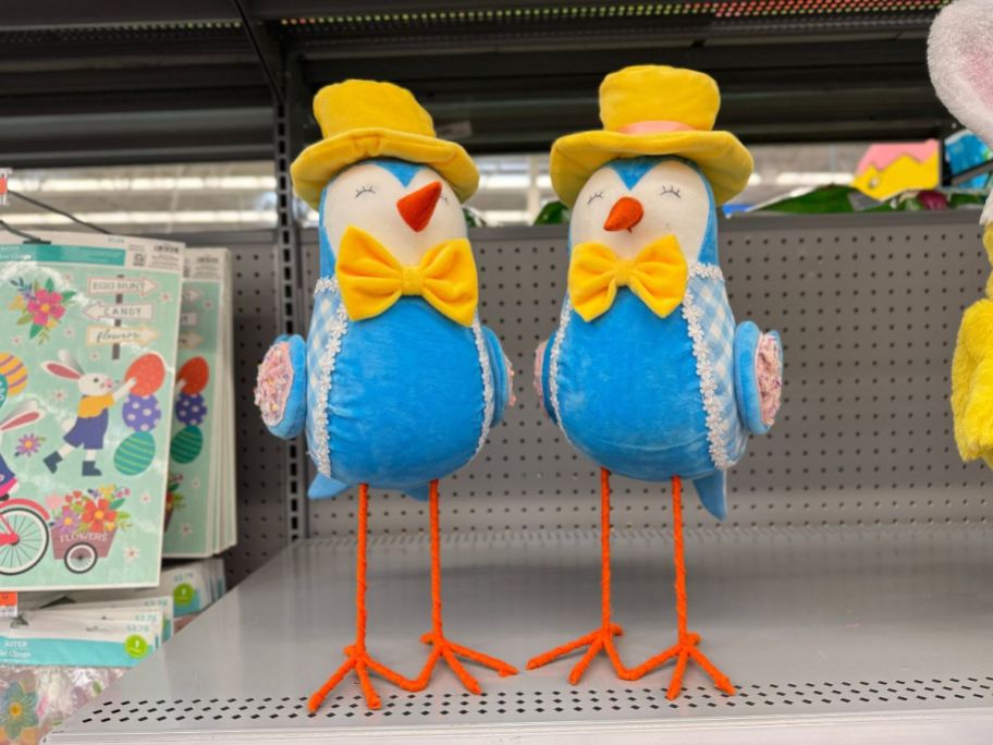 large, tall Easter decor birds with yellow hats and bowties standing on shelf