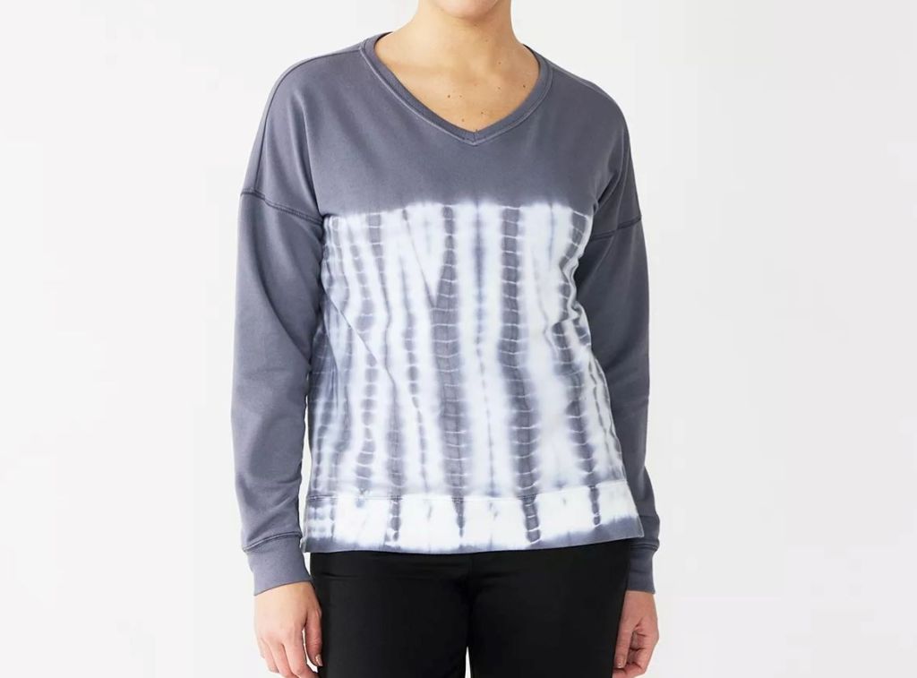 Woman wearing a grey sweatshirt with a grey and white tie-dye on the bottom half