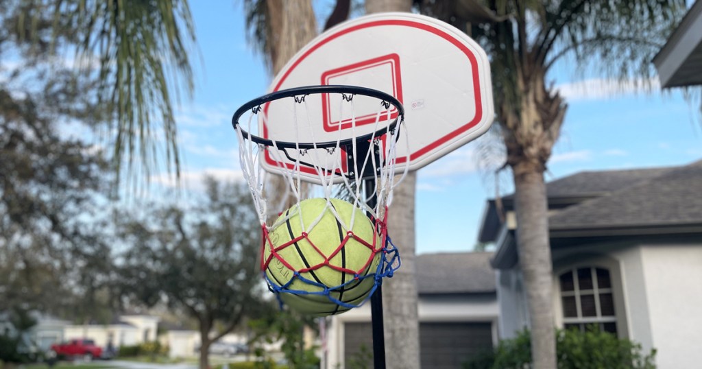 yellow basketball in hoop of basketball net