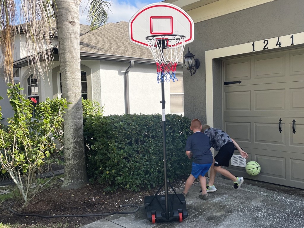 kids playing basketball near hoop in driveway