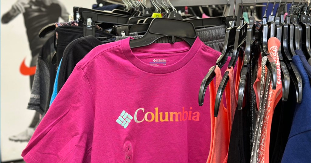 pink columbia shirt hanging on clearance rack with other clothes