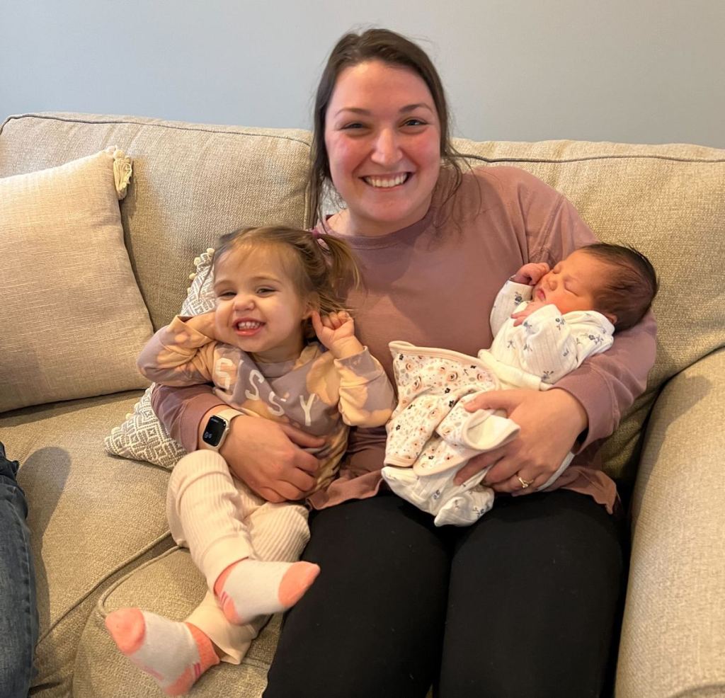 woman sitting on couch holding two babies