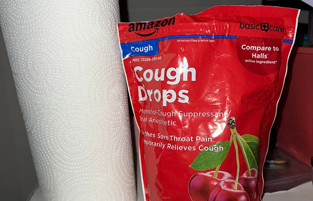 bag of amazon basic care cough drops next to a roll of paper towels