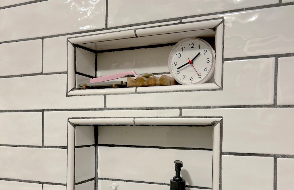 small shower clock on shelf in bathroom shower