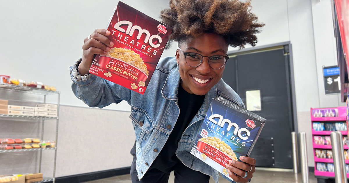 woman holding two boxes of amc popcorn boxes