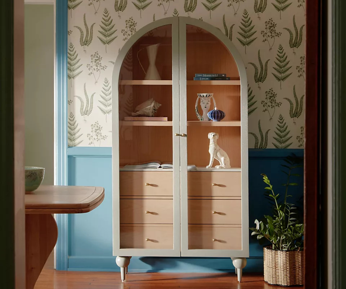 cabinet with rounded top in room with wallpaper