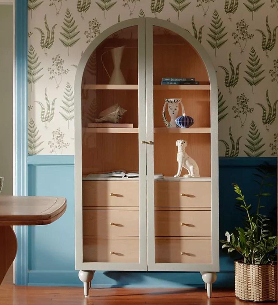 cabinet with rounded top in room with wallpaper