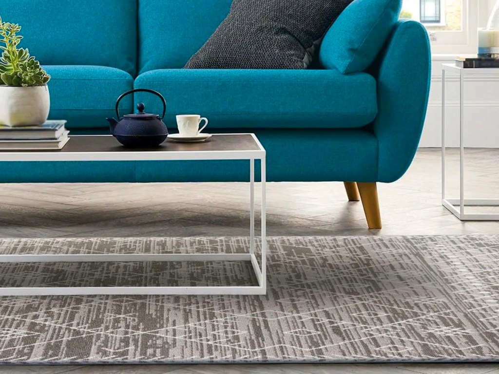 behnke gray and off white rug with coffee table on top and teal couch