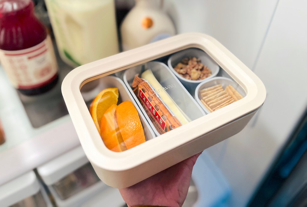 hand holding caraway food storage container with food inside bento style containers