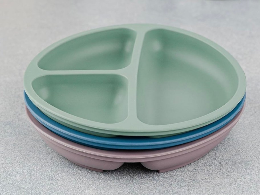 green, blue, and purple plates stacked together on table