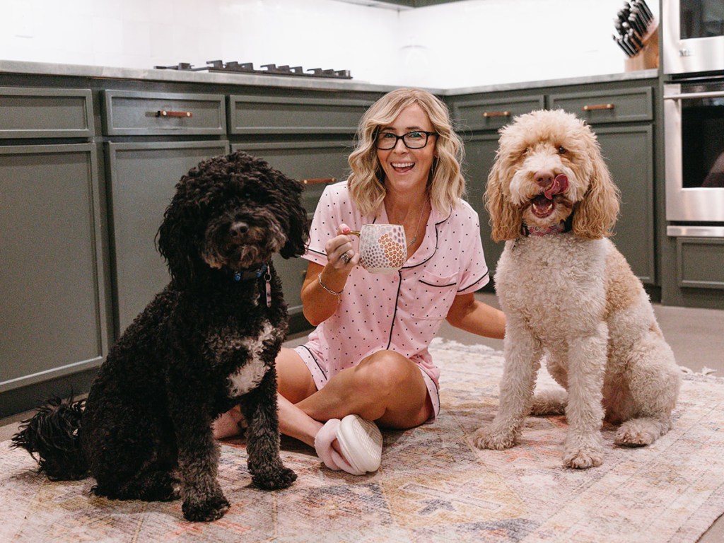 woman on kitchen floor with two dogs