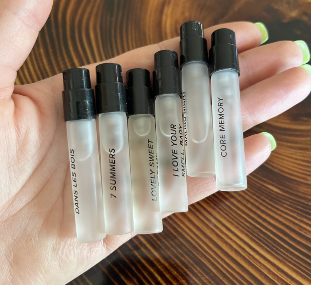 several perfume sample tubes in hand