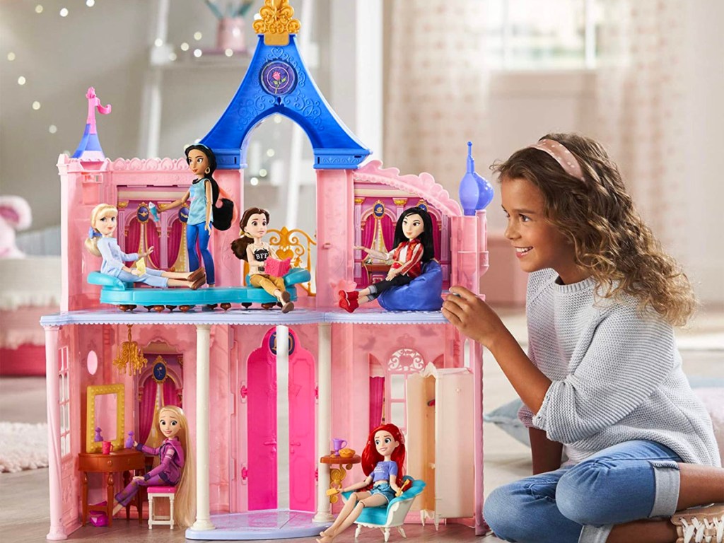 little girl playing with disney princess castle dollhouse