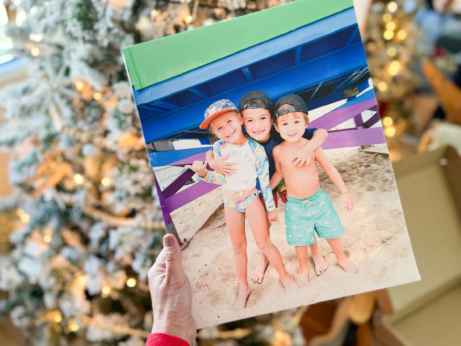 woman holding an easy canvas print featuring 3 children