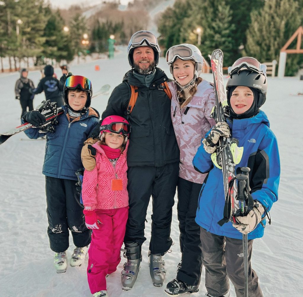 family wearing ski gear outside at resort