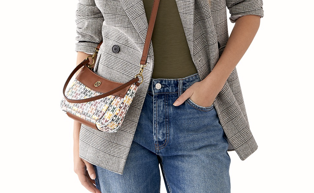 woman wearing a Fossil crossbody purse and standing with her hand in her pocket