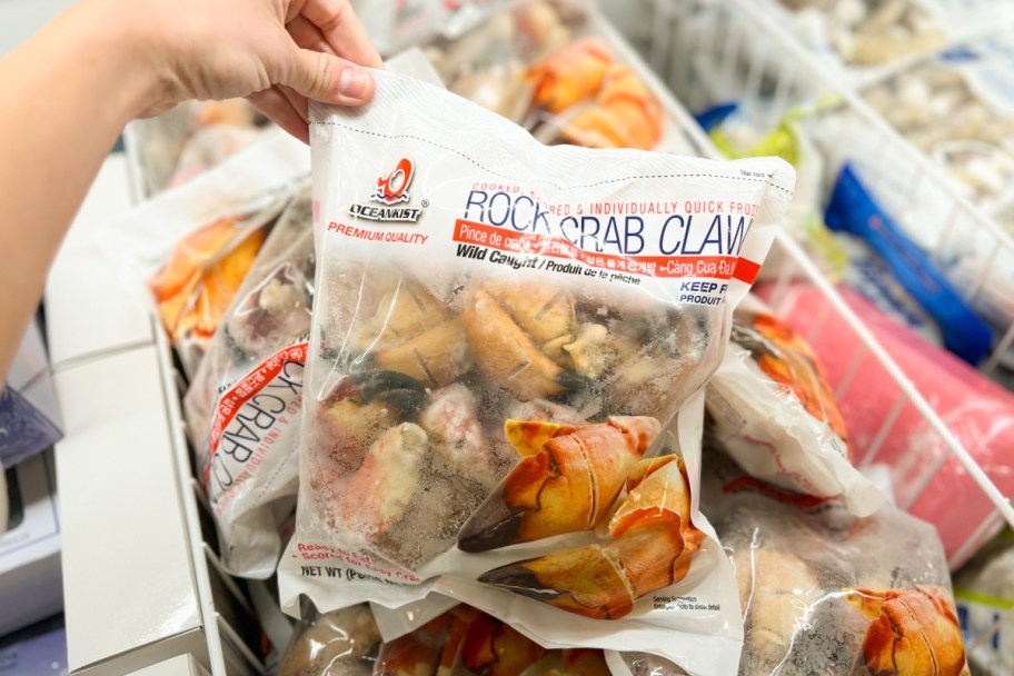 hand holding bag of frozen crab claws