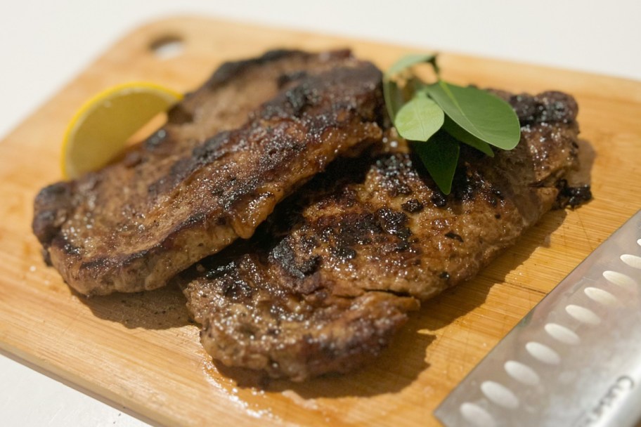 two cooked steaks on cutting board