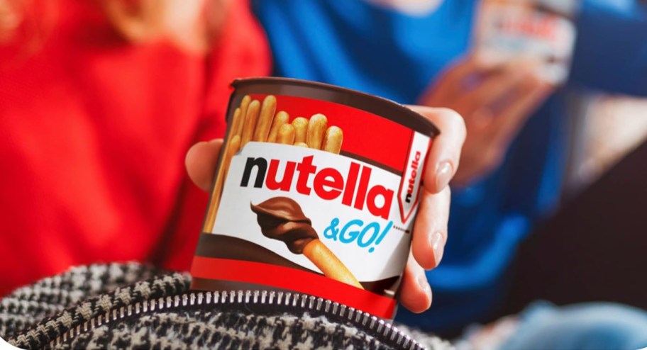 hand holding little Nutella & go cans