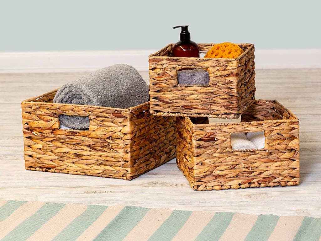 honey can do 3 nesting baskets on floor with blankets, lotion and other items inside