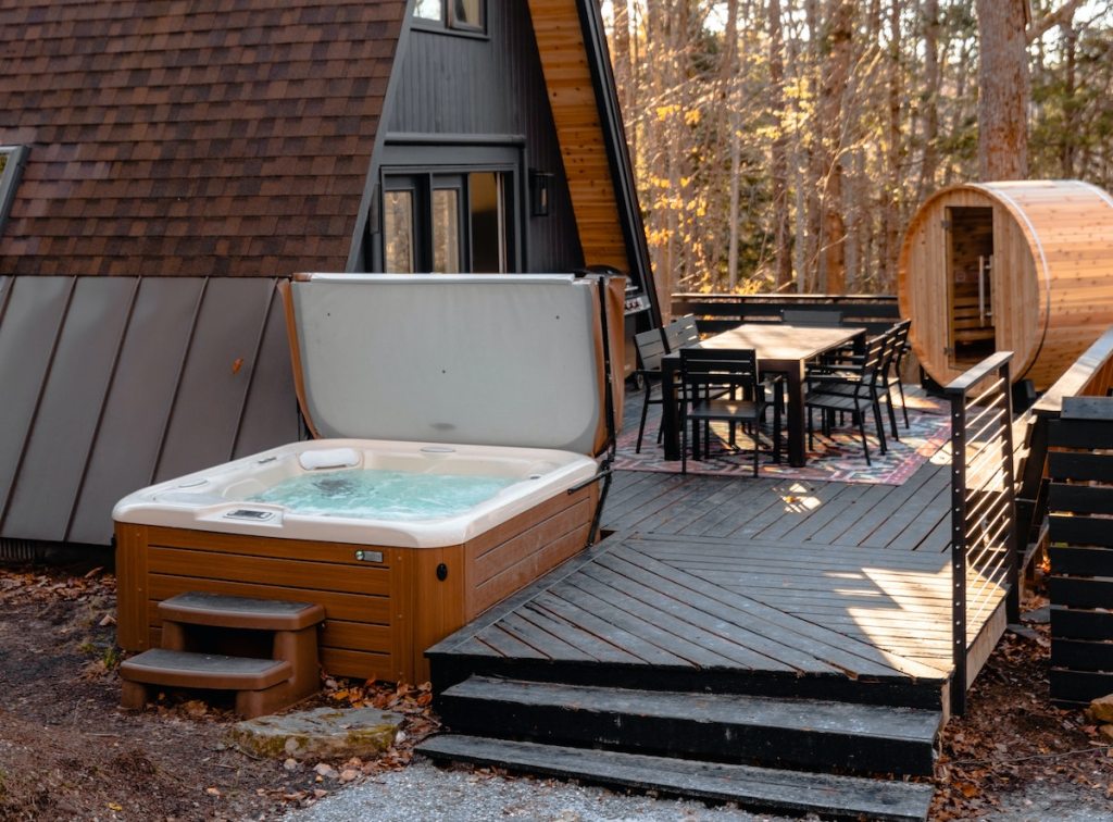 open airbnb essentials hot tub outside of a frame house