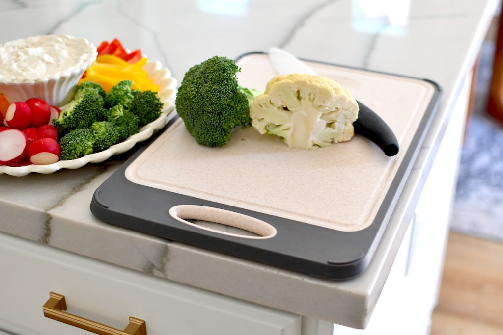 cutting board on countertop with veggies