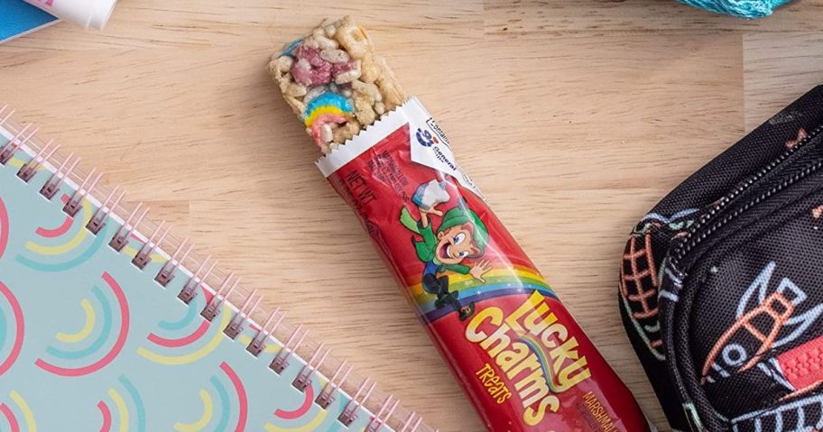 lucky charms bar next to a notebook and a lunch box