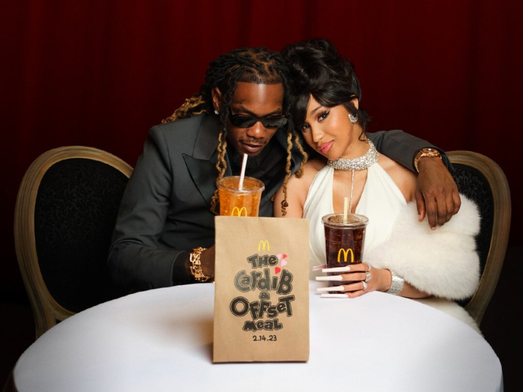 two people dressed formally and holding fountain drinks from McDonald's